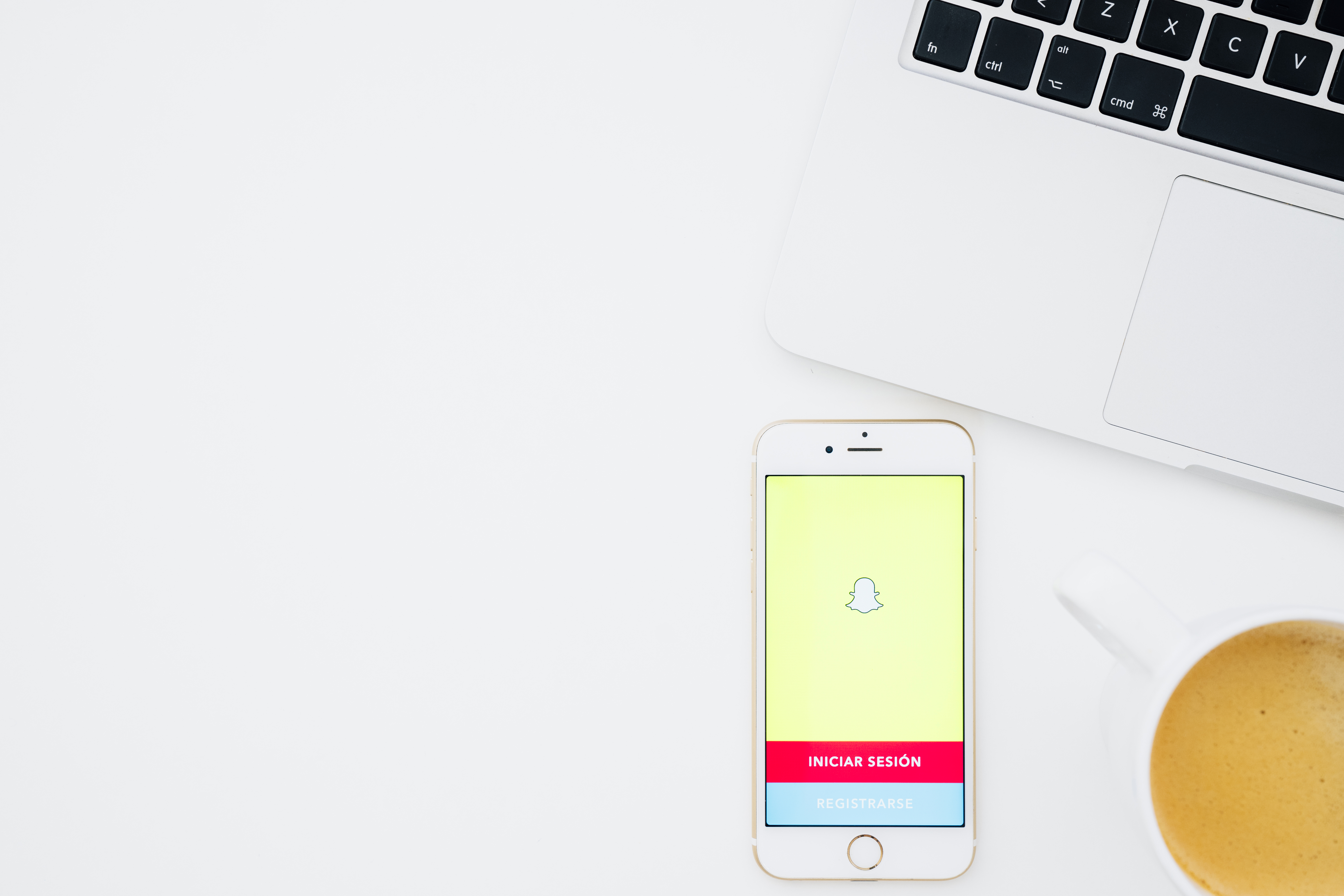 Picture of a macbook with an iphone open to the snapchat login screen